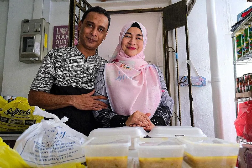 SUDUT KEBAIKAN RIQMAH: Encik Asanul Fariq Sani (kiri) dan isteri, Cik Norhasyimah Awaludin, membuka ruang infak di luar rumah untuk mengagihkan barangan keperluan dapur kepada golongan susah serta selendang dan tudung yang disumbangkan orang ramai. Ruang tersebut beroperasi hampir sepanjang tahun dan bermula dari 3 petang pada hari-hari biasa. - Foto BH oleh SHAFIQ APANDI