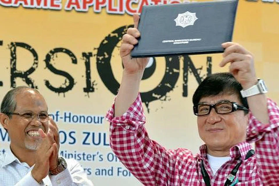 DUTA SELEBRITI ANTIDADAH: Encik Masagos Zulkifli (kiri) bertepuk tangan sebagai mengucap tahniah kepada bintang terkenal Jackie Chan yang dilantik menjadi duta antidadah Singapura. - Foto KHALID BABA