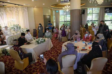 PASTIKAN KESELAMATAN: Walimah pasangan mempelai Md Faisal Haroon dan Raden Sofra Leezah Raden Abdul Rahman (gambar atas) di Plume Singapore di Singapore Flyer ini memastikan semua langkah keselamatan dijalankan. - Foto BM oleh MARK CHEONG