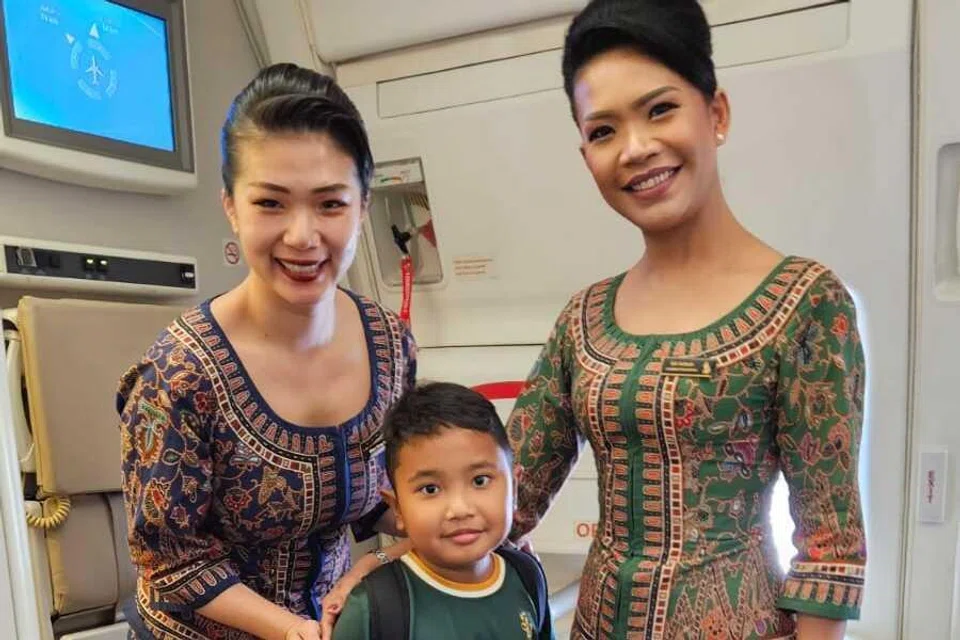 Kyle Mishary Hirman bersama kru kabin yang menerima hadiah bungkusan kecil mengandungi snek daripadanya.