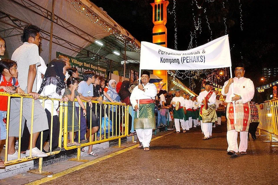 MERIAHKAN ACARA: Kumpulan hadrah kompang Pehaks (gambar kiri) membentuk sebahagian daripada kontijen yang membuat persembahan sempena acara penyalaan lampu Hari Raya Puasa di Geylang Serai pada 2005. - Foto fail