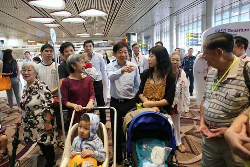 MAHU LIHAT KEMUDAHAN BARU: Encik Khaw (menuding ke depan) berbual-bual dengan pengunjung di Rumah Terbuka di Terminal 4 semalam. - Foto THE STRAITS TIMES