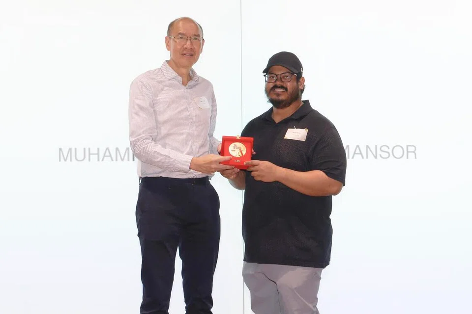 Ketua jurulatih pasukan sukan angkat berat atau ‘powerlifting’ para nasional, Muhammad Abdul Razak Mansor (kanan), antara 214 jurulatih daripada 79 sukan yang diiktiraf di Majlis Penghargaan Jurulatih pada 13 Februari. Razak merupakan antara lebih 80 jurulatih yang hadir semasa majlis tersebut untuk menerima pingat penghargaan. Beliau menerima pingatnya daripada pengerusi Majlis Sukan Singapura (SportSG), Kon Yin Tong (kiri).