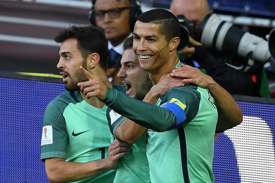 SENTUHAN CEMERLANG: Bintang Portugal, Cristiano Ronaldo (kanan), meraikan gol kemenangan ke atas Russia, sekali gus meletak pasukannya dalam kedudukan baik untuk melayakkan diri ke separuh akhir Piala Konfederasi ini. - Foto AFP