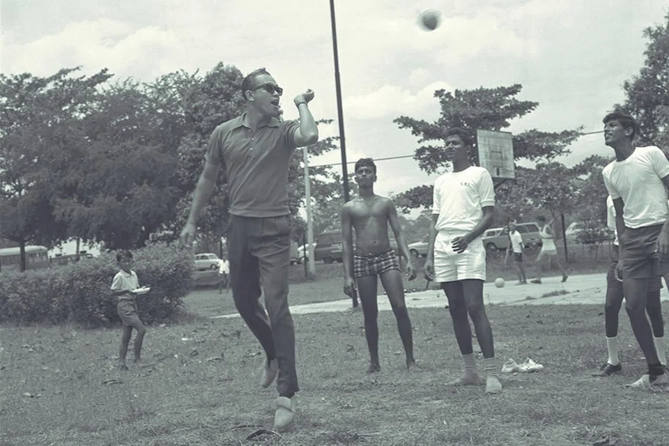 SOKONG SUKAN UNTUK SEMUA: Encik Othman mencuba bakat bermain sepak takraw, semasa menjadi tetamu di acara Rumah Kebajikan Sosial Gabungan pada 11 Oktober 1970. - Foto fail 