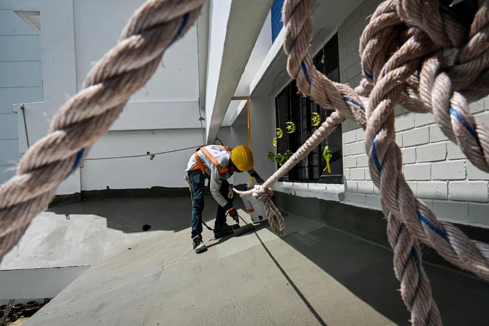 Kerja penyenggaraan sedang dilakukan dengan seorang pekerja kelihatan sedang mengecat bumbung tingkat dua di Blok 119, Bedok Reservoir Road.