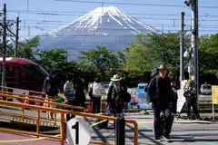 Pelancong asing tiba di stesen Kawaguchiko dengan latar belakang Gunung Fuji. Wilayah Yamanashi telah memperkenalkan tempahan secara dalam talian bagi sesiapa masuk ke kawasan gunung itu menerusi Laluan Yoshida. 