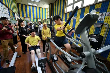 PELBAGAI PROGRAM PEMBELAJARAN: Presiden Halimah Yacob berpeluang berinteraksi dengan beberapa pelajar Sekolah Metta yang sedang bersenam di gim sekolah itu semasa lawatannya ke sana semalam, di mana beliau diperkenalkan kepada pelbagai program pembelajaran. - Foto BH oleh LIM YAOHUI