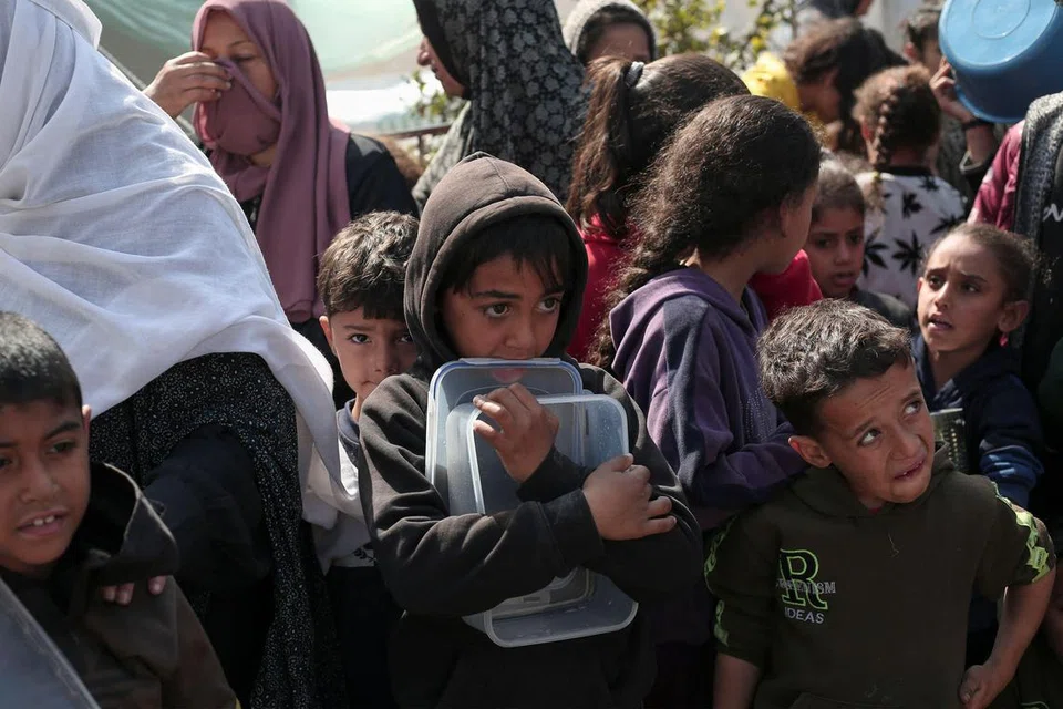 Penduduk termasuk kanak-kanak Palestin berkumpul untuk mendapatkan makanan di Rafah, selatan Semenanjung Gaza pada 28 Februari 2024, di tengah-tengah pertempuran berterusan antara Israel dengan Hamas.