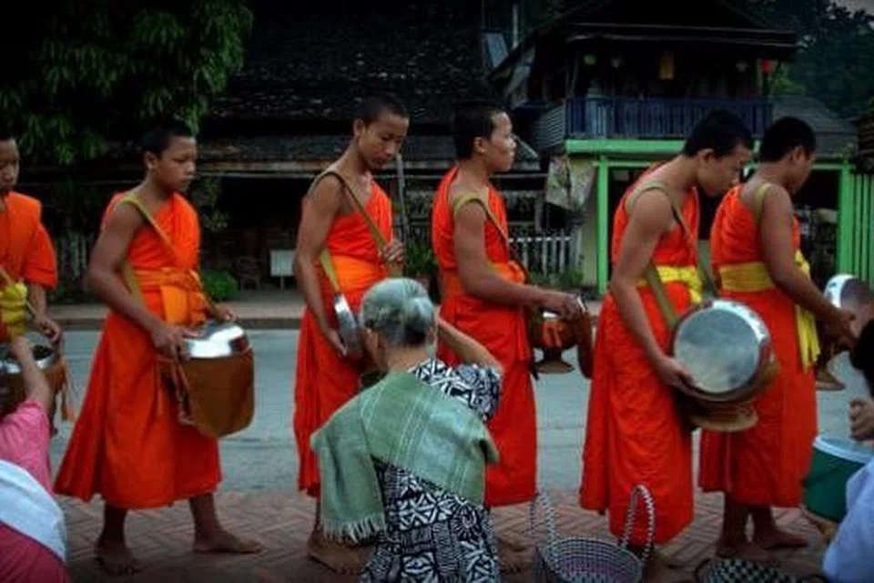 BERATUR MENERIMA DERMA: Sami Buddha menerima sumbangan ramai dalam upacara keagamaan, Tak Bat, yang sudah menjadi daya tarikan pelancong. - Foto-foto MOKSIM SALEH