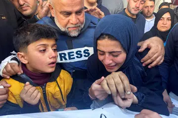 MANGSA PEPERANGAN: Pengarang Aljazeera, Encik Wael Al-Dahdouh, mendakap anak perempuan dan anak lelakinya di upacara pengebumian anaknya, Encik Hamza Al-Dahdouh, seorang wartawan yang terbunuh dalam serangan Israel di Rafah, selatan Gaza.