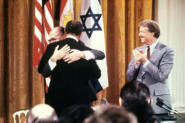 Pada 17 September 1978, Presiden Mesir Anwar al-Sadat (kiri) dan Perdana Menteri Israel Menachem Begin berpelukan selepas menandatangani perjanjian damai bersejarah di Rumah Putih. Upacara tersebut disaksikan oleh Presiden Amerika Syarikat ketika itu, Encik Jimmy Carter (kanan), yang memainkan peranan penting dalam rundingan tersebut.