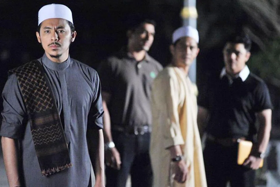 RAMAI MENANTI TAYANGAN: Syamsul Yusof (kiri) pengarah filem Munafik 2 turut berlakon membawa watak Ustaz Adam yang bertarung dengan kuasa-kuasa jahat untuk meruntuhkan keluarganya. - Foto SKOP PRODUCTIONS