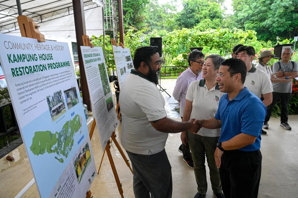 Menteri Pembangunan Negara, Encik Desmond Lee (depan, kanan), diberikan taklimat tentang usaha Lembaga Taman Negara (NParks) bagi Projek Ubin semasa meraikan Hari Ubin pada 22 Jun.