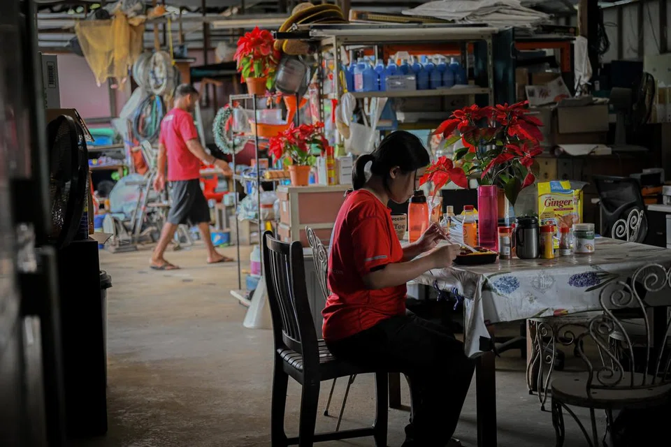 MAKAN SECARA SEDERHANA: Cik Hillary Lee duduk di dapur ladang untuk makan tengah hari yang dibeli dari pusat beli-belah Lot 10 malam sebelumnya, sejuk dan tidak panas kerana ketiadaan microwave.