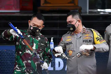 TUNJUK BUKTI: Pegawai keselamatan menunjukkan bukti senjata yang dikatakan kepunyaan anggota Front Pembela Islam (FPI) yang menyerang polis awal pagi kelmarin. - Foto REUTERS