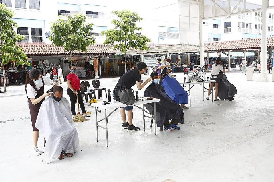 KERJA KERAS DIHARGAI: Pekerja pembersihan di kawasan Nee Soon East diberikan potongan rambut percuma oleh kedai gunting rambut Backalley Barbers di bawah inisiatif memberi penghargaan kepada pekerja pembersihan, 'Home with a Heart'. - Foto PERSATUAN RAKYAT