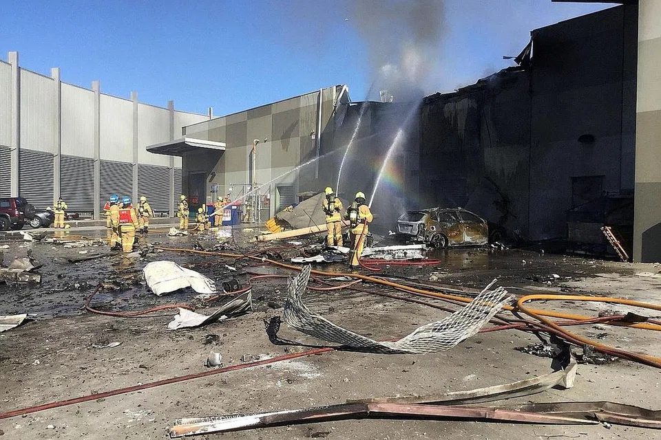 KEMALANGAN RAGUT NYAWA: Anggota bomba sedang memadamkan kebakaran selepas sebuah pesawat ringan terhempas di atas pusat beli-belah dekat Melbourne semalam. - Foto AFP