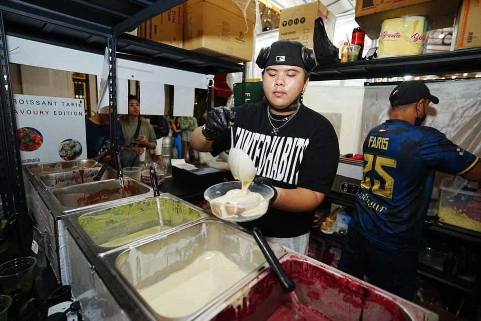 Encik Koji Izaack, yang menguruskan operasi kedai, membanjiri pastri kroisan yang baru dibakar dengan sos coklat putih. 