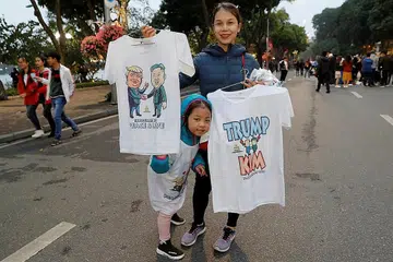 SIDANG PUNCAK: Seorang wanita menjual kemeja T menggambarkan pemimpin Korea Utara, Encik Kim Jong Un dan Presiden Amerika, Encik Donald Trump menjelang sidang kemuncak di Hanoi. - Foto REUTERS