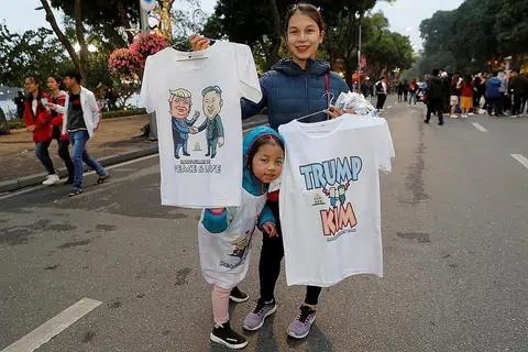 SIDANG PUNCAK: Seorang wanita menjual kemeja T menggambarkan pemimpin Korea Utara, Encik Kim Jong Un dan Presiden Amerika, Encik Donald Trump menjelang sidang kemuncak di Hanoi. - Foto REUTERS