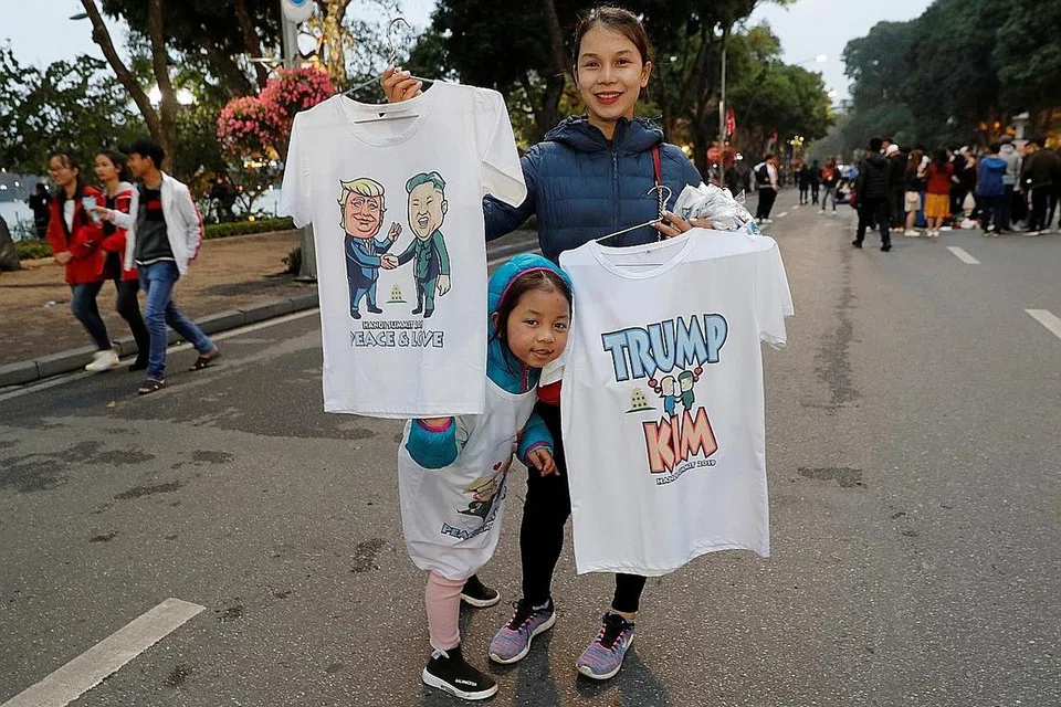 SIDANG PUNCAK: Seorang wanita menjual kemeja T menggambarkan pemimpin Korea Utara, Encik Kim Jong Un dan Presiden Amerika, Encik Donald Trump menjelang sidang kemuncak di Hanoi. - Foto REUTERS