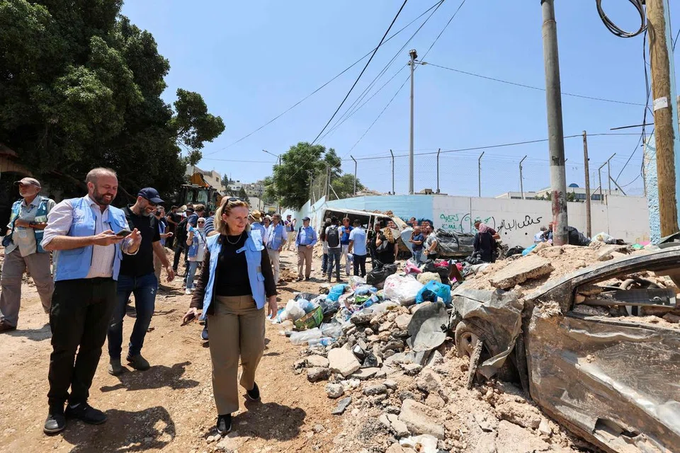 TIADA PENYELESAIAN: Anggota delegasi utusan antarabangsa melihat puing-puing runtuhan semasa lawatan ke kem pelarian Palestin di Jenin, Tebing Barat yang diduduki Israel, pada 8 Julai.