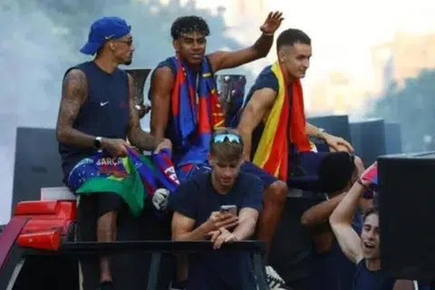 Pemain FC Barcelona, ​​Lamine Yamal (tengah) semasa perarakan bas pada 11 Mei ketika mereka meraikan kemenangan kejuaraan La Liga.