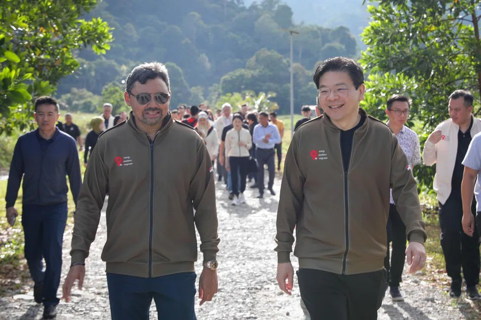 SEIRING JALAN: Timbalan Perdana Menteri, Encik Lawrence Wong (kanan) berjalan-jalan di waktu pagi bersama  Putera Mahkota yang juga Menteri Kanan di Pejabat Perdana Menteri Brunei, Putera Al-Muhtadee Billah. Mereka disertai ahli rombongan masing-masing. 