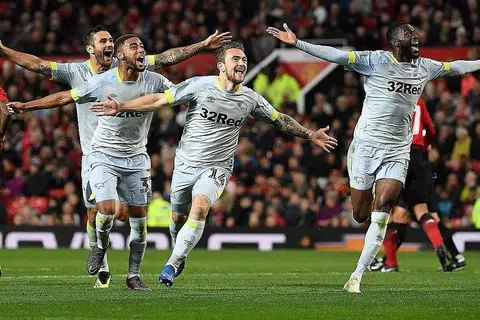 RAIKAN GOL: Penyerang Derby, Jack Marriott (tengah) meraikan gol kedua pasukannya ketika menentang Manchester United pagi semalam. Derby menewaskan Manchester United yang beraksi 10 orang 8-7 dalam penentuan penalti untuk menempah tempat ke kelompok 16 terakhir Piala Liga. - Foto AFP