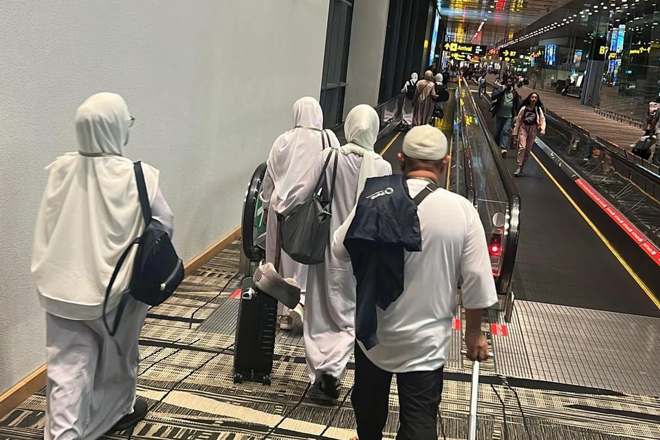 TIDAK DAPAT BERANGKAT: Jemaah kelihatan berjalan ke kawasan imigresen di Terminal 3 Lapangan Terbang Changi selepas pesawat SV837 yang sepatutnya berangkat ke Jeddah pada Jumaat, 5 petang ditangguh hingga Ahad 3.30 petang.