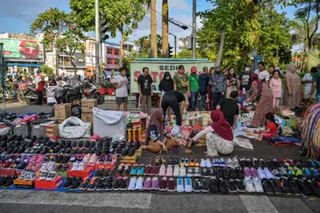 Orang ramai membeli barangan keperluan rumah di sebuah gerai di Surabaya pada 13 Julai 2025 sedang pegawai kanan Indonesia memaklumkan bahawa negara tersebut masih merundingkan butiran terperinci perjanjian perdagangan terbaru dengan Amerika Syarikat.