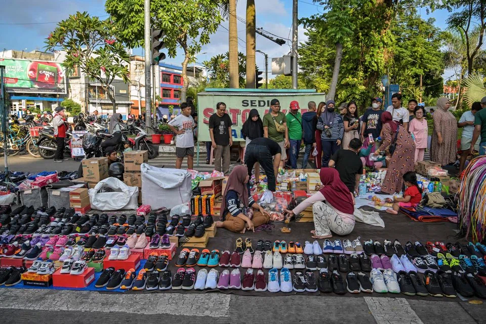 Orang ramai membeli barangan keperluan rumah di sebuah gerai di Surabaya pada 13 Julai 2025 sedang pegawai kanan Indonesia memaklumkan bahawa negara tersebut masih merundingkan butiran terperinci perjanjian perdagangan terbaru dengan Amerika Syarikat.