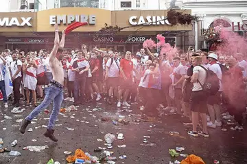 PUNCA HUKUMAN: Penyokong England melempar sebatang pokok ketika mereka berkumpul di Leicester Square berhampiran Trafalgar Square sebelum perlawanan akhir Euro 2020 di Stadium Wembley pada 11 Julai. - Foto EPA-EFE