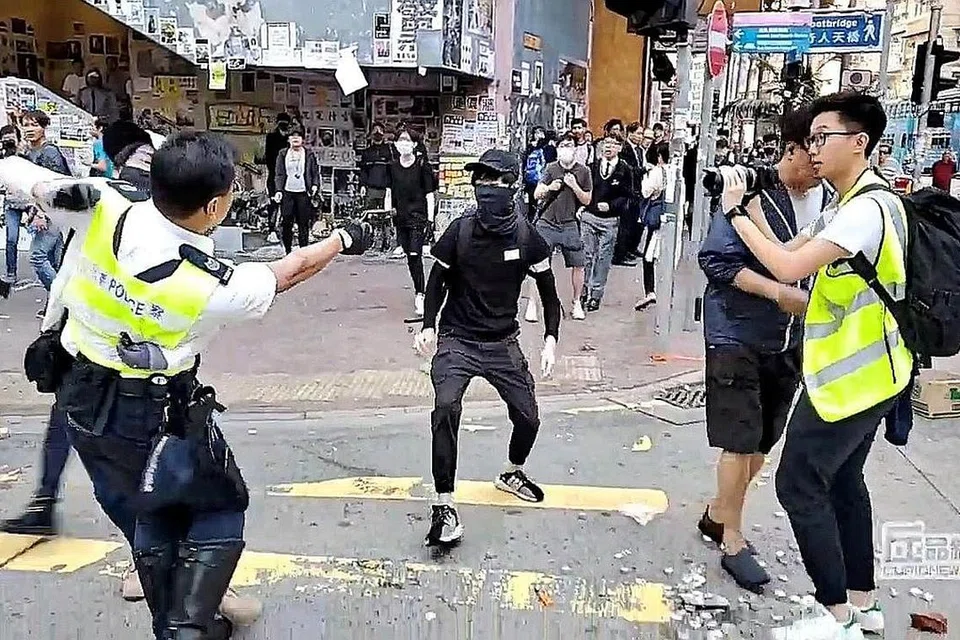 VIDEO NGERI: Tangkap layar video yang menular di media sosial semalam menunjukkan pegawai polis mengacukan pistol pada penunjuk perasaan di Sai Wan Ho, Hong Kong. - Foto REUTERS
