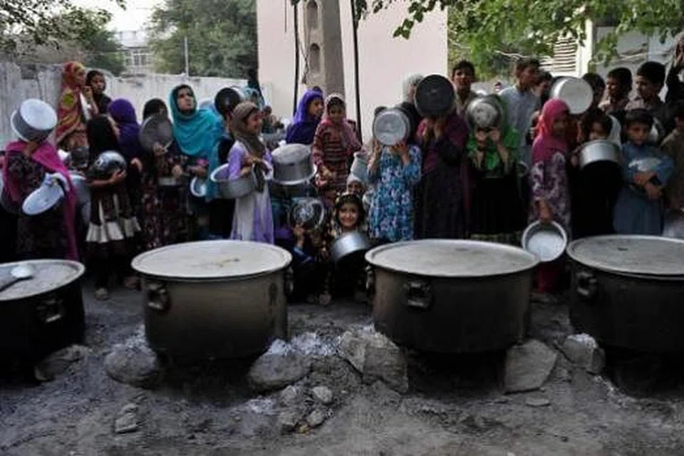 MENANTI HIDANGAN BUKA: Kanak-kanak di Jalalabad, Afghanistan, menunggu untuk diberi makanan buat berbuka puasa yang didermakan sebuah badan amal swasta Ahad lepas. - Foto-foto AFP dan REUTERS.