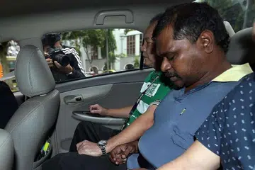 Thennarasu Karupiah (tengah) dituduh membunuih dengan niat Encik Arokiasamy Paul Rajoo di Taj Mahal Bollywood Music Lounge. Dia menghadapi hukuman mati mandatori jika sabit kesalahan. 