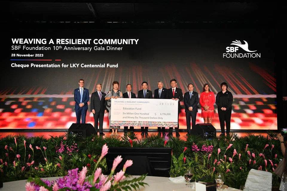 USAHA BERSAMA: Cek bernilai $6.196 juta telah disampaikan oleh Timbalan Pengerusi Yayasan Persekutuan Perniagaan Singapura (SBF), Cik Janet Ang (tiga dari kiri), kepada Menteri Pendidikan, Encik Chan Chun Sing (empat dari kanan), sambil disaksikan oleh Timbalan Perdana Menteri, Encik Lawrence Wong (lima dari kiri), pada Selasa di The Ritz-Carlton, Millenia Singapore sebagai sebahagian daripada sambutan ulang tahun ke-10 Yayasan SBF.