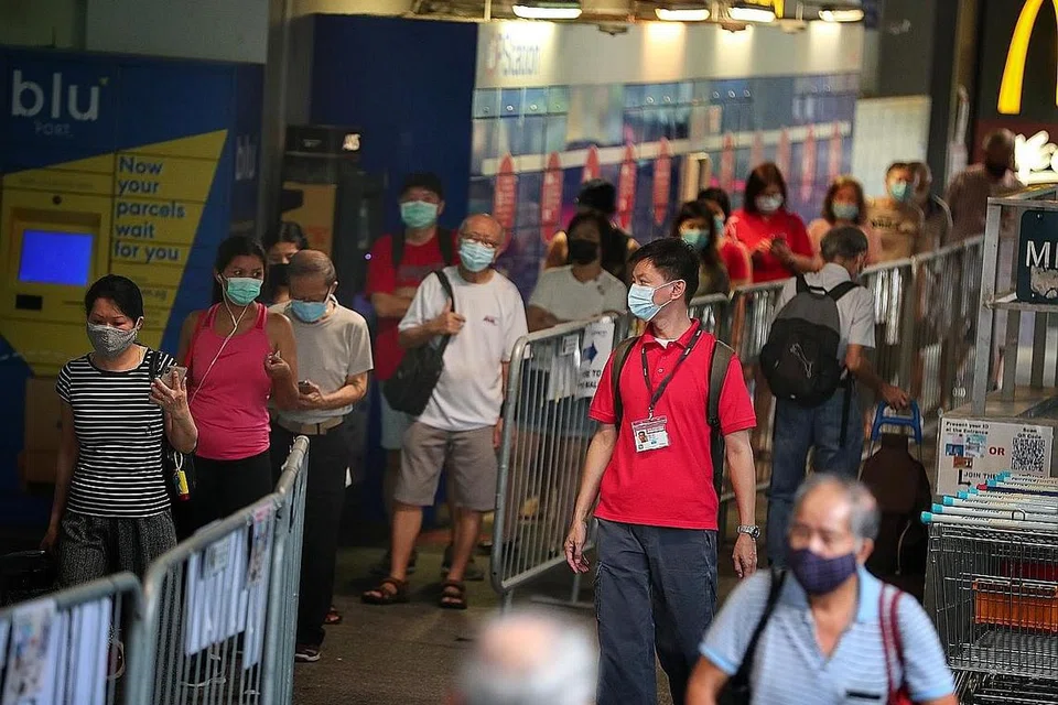 PASTIKAN JARAK SELAMAT: Seorang duta jarak selamat (berbaju merah) melakukan rondaan di Clementi Mall untuk memastikan orang ramai mematuhi langkah jarak selamat, terutama ketika beratur. - Foto fail