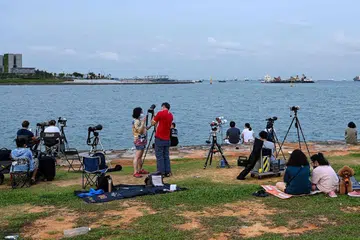 SAKSIKAN FENOMENA: Warga bersiap dengan teropong dan camera untuk menyaksikan gerhana bulan. - Foto AFP