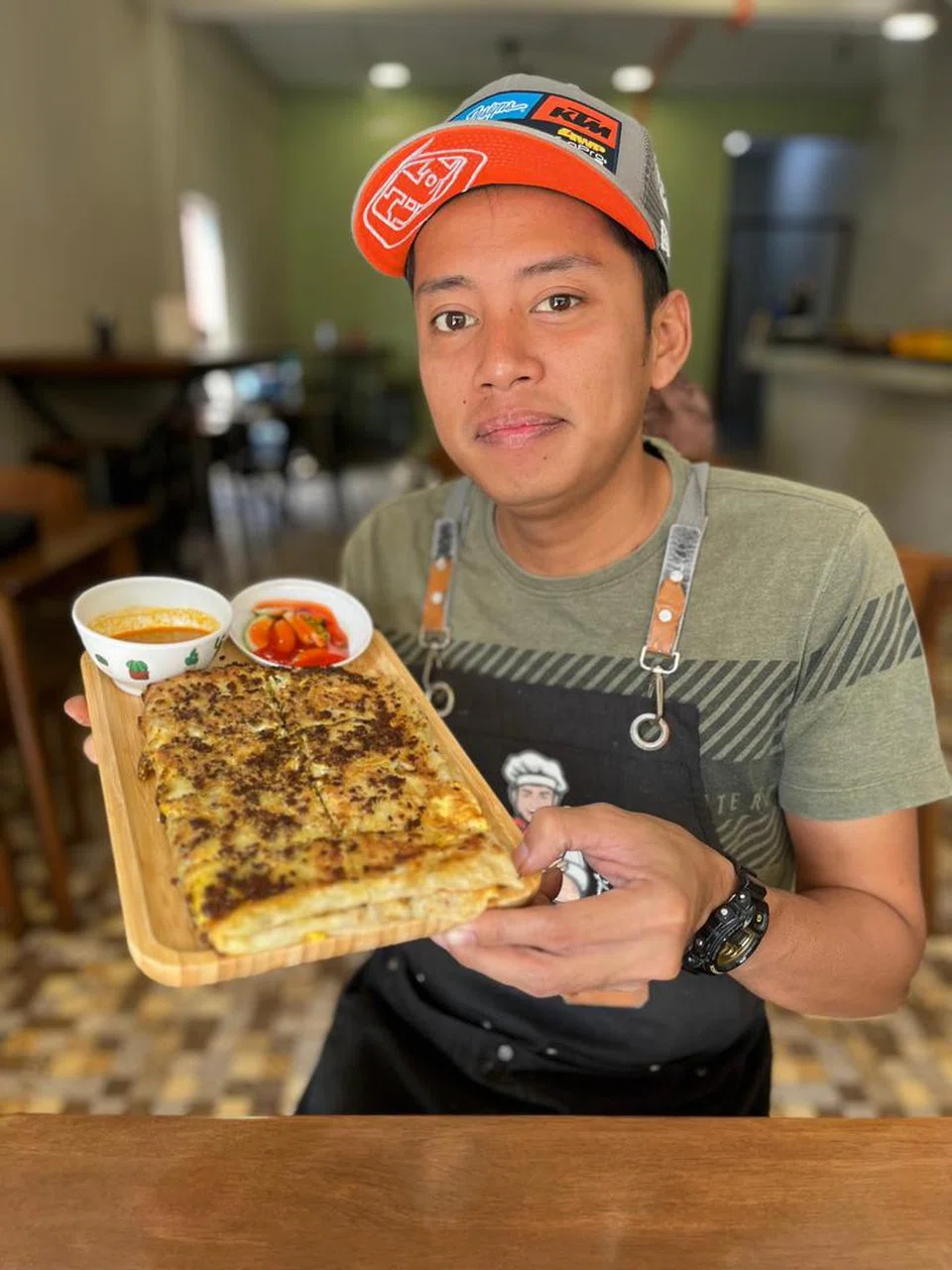 Pemilik perniagaan ‘Murtabak Singapore Dari Rumah’, Encik Mohd Daniel Shukor, 34 tahun, menunjukkan martabak yang dijual di gerainya di Taman Melawati, Kuala Lumpur.