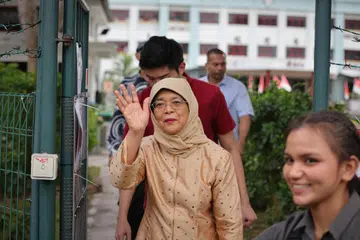 TURUT SERTA UNDI: Presiden kelapan Singapura, Puan Halimah Yacob, tiba di Sekolah Menengah Chung Cheng pada sekitar 8.15 pagi untuk mengundi dan memilih peggantinya.