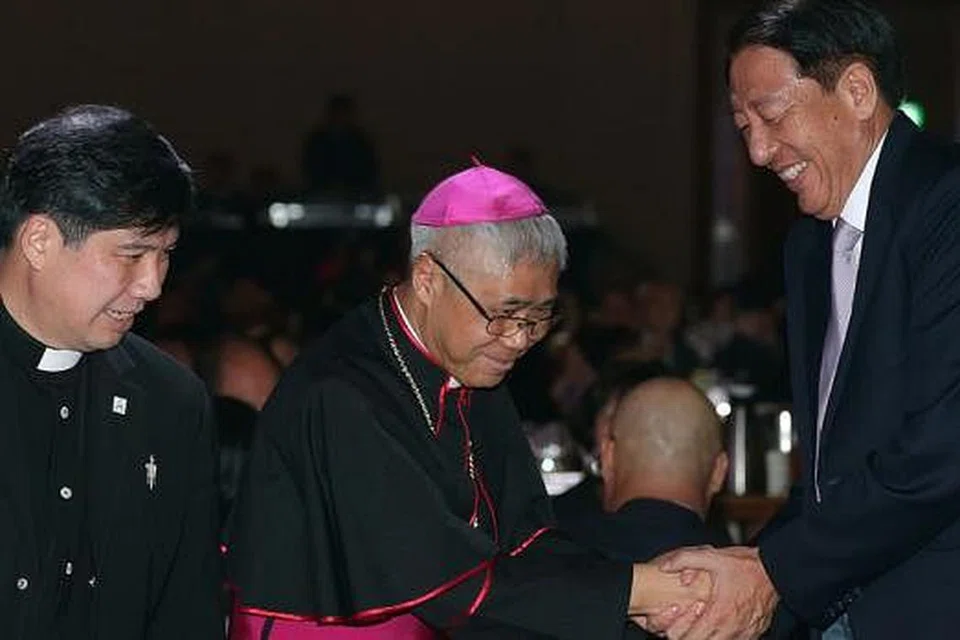 SALAM MUHIBAH: (Dari kanan) Encik Teo beramah-tamah dengan Ketua Biskop William Goh dan Paderi Church of Transfiguration Joachim Chang di majlis jamuan malam bagi mengumpul dana untuk gereja yang akan dibina di Punggol itu. - Foto THE STRAITS TIMES