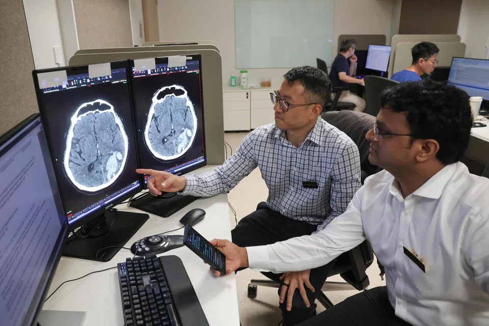 Ketua jabatan neuroradiologi di Hospital Besar Singapura (SGH) dan Institut Neurosains Kebangsaan (NNI), Dr Robert Chen (kiri), menyemak keputusan AI dan imbasan CT pesakit bersama Dr Sarat Kumar Sanamandra, perunding kanan di jabatan yang sama.