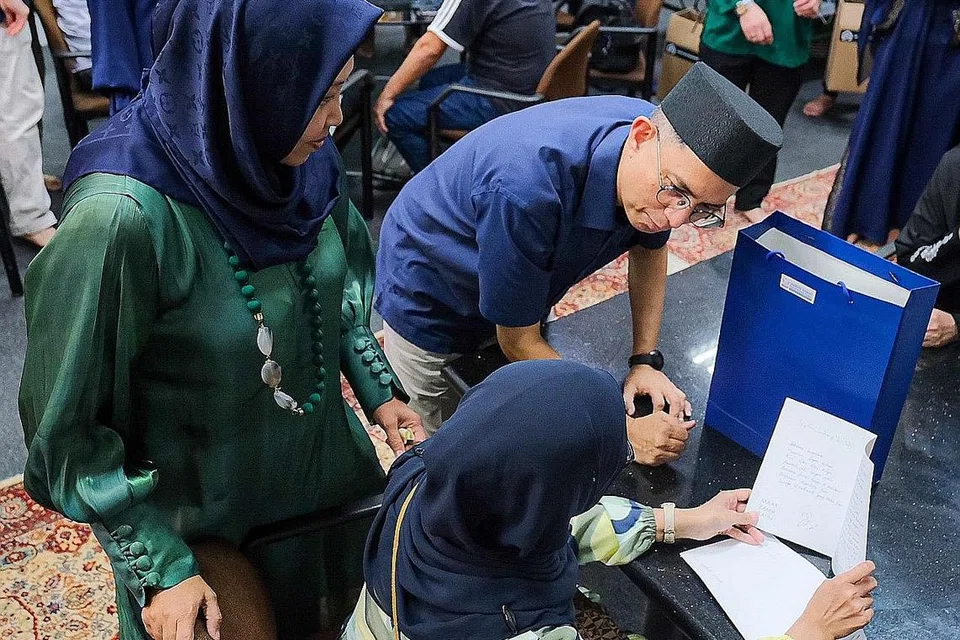 BEKERJASAMA DENGAN RAKAN KONGSI: Dr Muhammad Faishal Ibrahim dan Setiausaha kehormat HGEF, Cik Haslinda Putri Harun (kiri), mengagih habuan perayaan semasa projek Pelita Hati pada April. - Foto BH oleh SHAFIQ APANDI