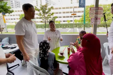Menteri yang menerajui pasukan Parti Tindakan Rakyat (PAP) di GRC Sembawang, Encik Ong Ye Kung, bersama anggota pasukan, Cik Mariam Jaafar, mendekati penduduk di Sembawang Mart sambil berkongsi tentang acara Rumah Terbuka Hari Raya di Sembawang pada 26 April.