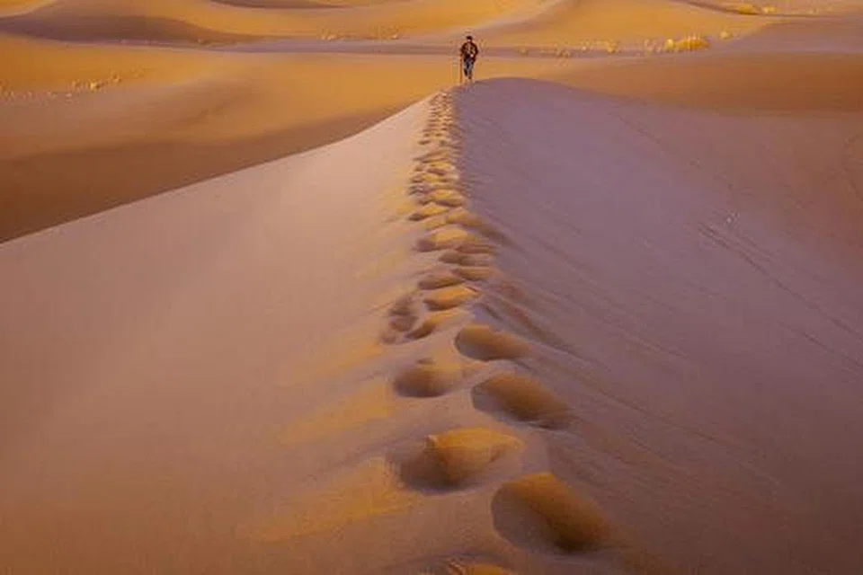 MENGENAL DIRI DALAM SUASANA ASING: Setiap kembara Encik Muhammad Noor Iskandar Othman ke negara eksotik mendekatkannya dengan proses mengenali diri dalam suasana yang asing, seperti foto seorang lelaki yang berjalan seorang diri di bukit pasir sekitar Yazd, Iran (gambar), yang dirakam beliau sebagai gambaran seseorang yang sedang mencari ketenangan dan keinsafan diri tanpa ditemani sesiapa, kecuali Tuhan. - Foto ihsan MUHAMMAD NOOR ISKANDAR OTHMAN