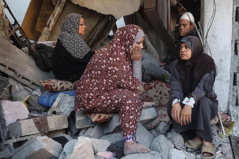 Penduduk Palestin duduk termenung di atas puing-puing bangunan yang runtuh akibat dibom tentera Israel dalam serangan di Nuseirat, tengah Gaza, pada 5 Disember.