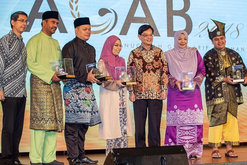 SUMBANGAN DIIKTIRAF: Encik Heng Swee Keat (tiga dari kanan) dan Profesor Madya Muhammad Faishal Ibrahim (kiri) menyampaikan Anugerah Guru Arif Budiman (Agab) 2018 kepada (dari kanan) Encik Amirul Asri Hussin, Cik Rita Zarina Mohd Nazeer, Cik Khairyanie Kamsani, Encik Roslie Buang Sidik dan Encik Mohamad Zareen Mohamad Shariff di Grand Ballroom Orchid Country Club semalam. - Foto BM oleh ZALEHA ABDUL KADER