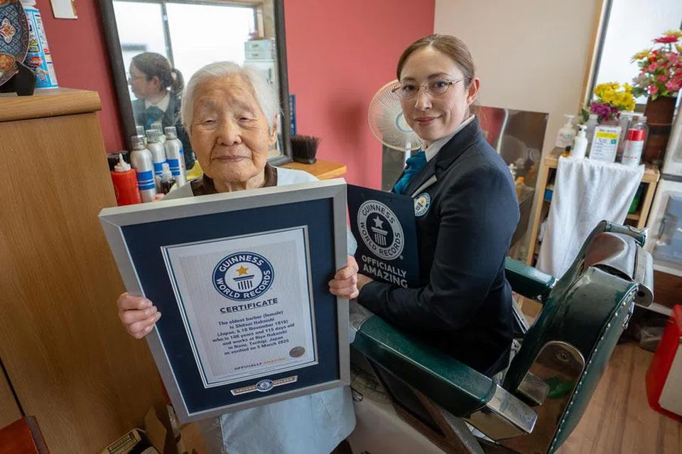 Seorang wakil Guinness World Records menyerahkan sijil pengiktirafan kepada Cik Shitsui Hakoishi sebagai tukang gunting tertua di dunia pada usia 108 tahun.